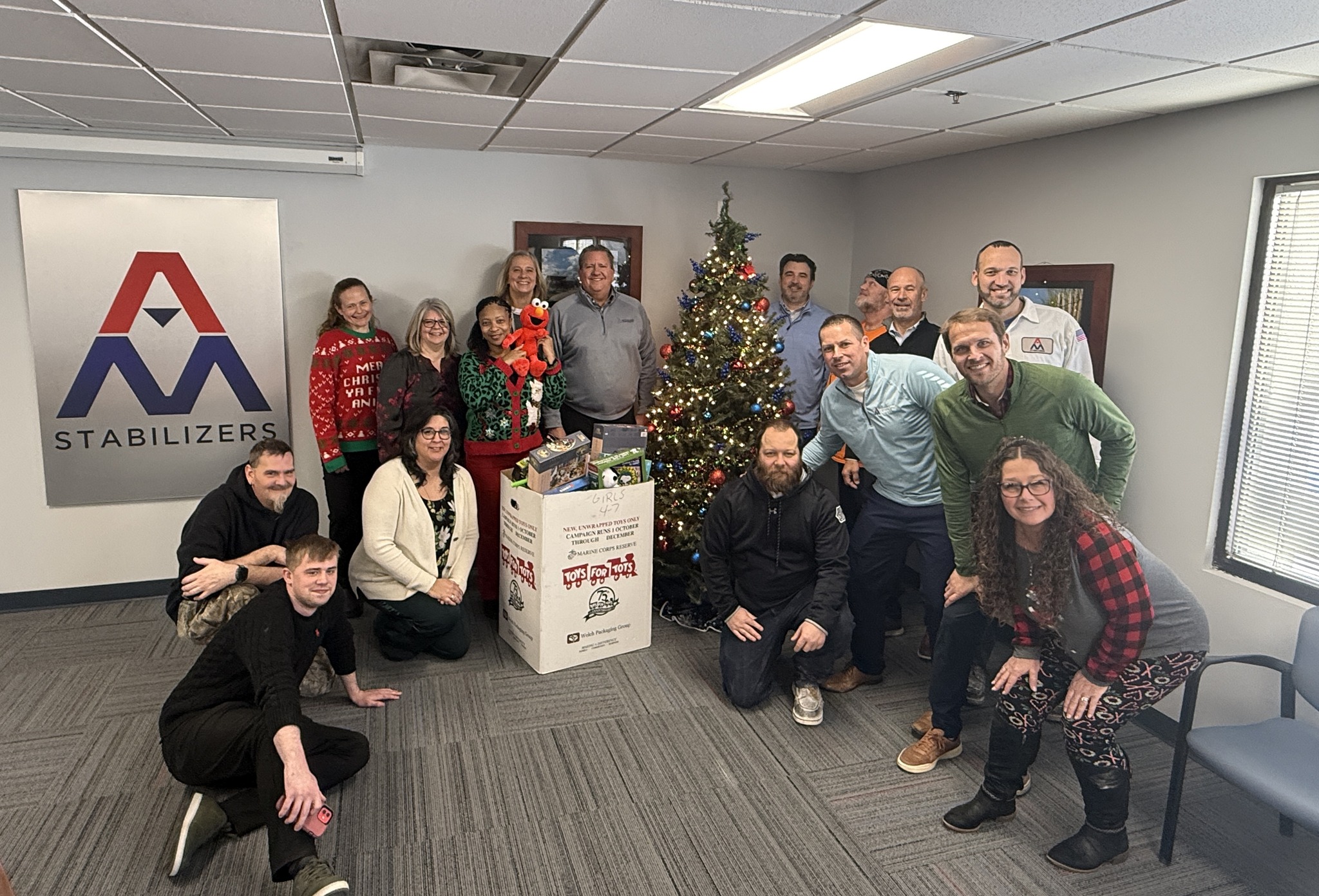 Group photo with toys collected for Toys for Tots